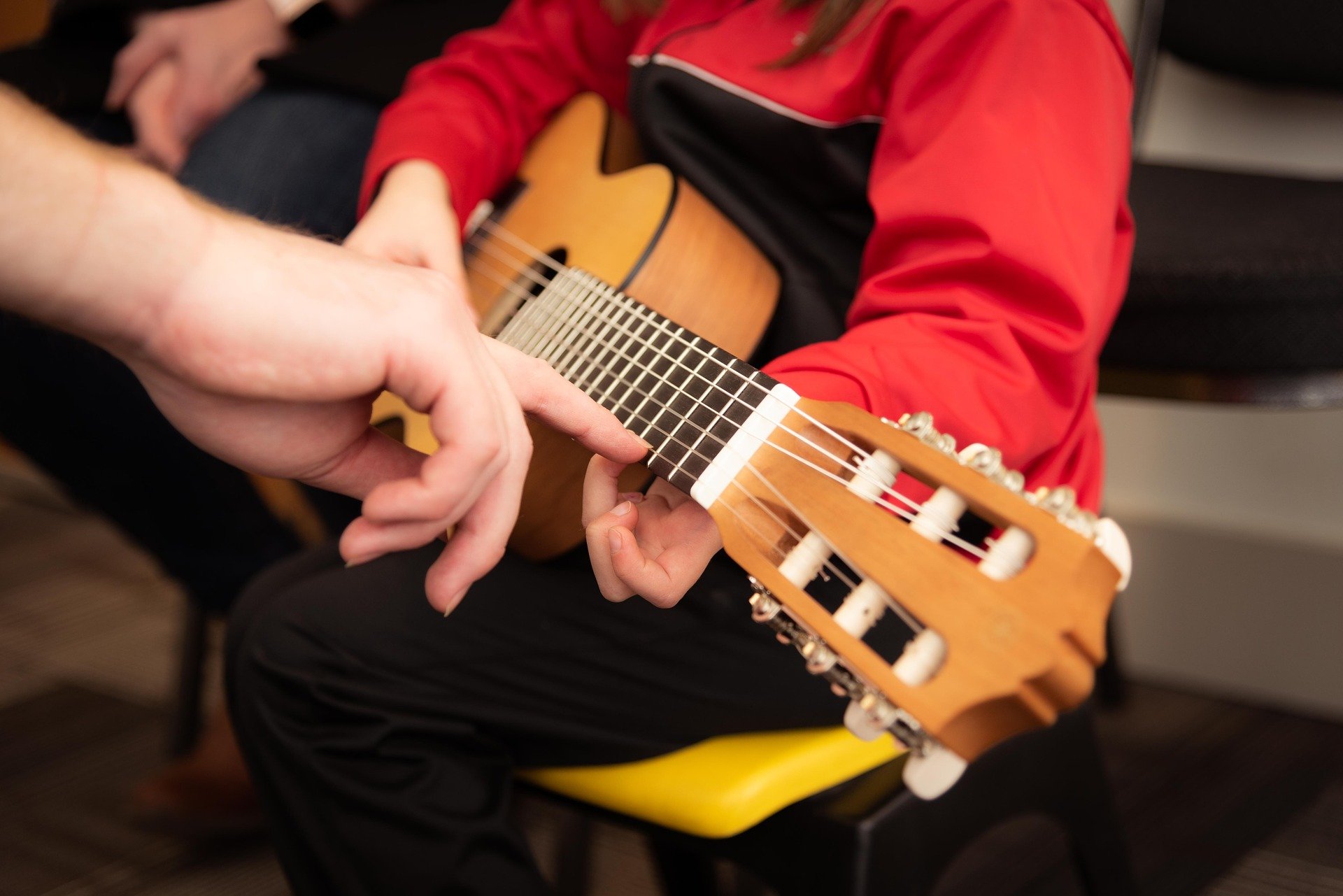 Ein Bild, das Gitarrenunterricht veranschaulicht.